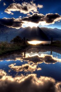 Preview wallpaper sun, clouds, lake, reflection, light, shadows, mountains, sky