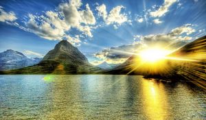 Preview wallpaper sun, light, beams, lake, evening, decline, ripples, mountains, peaks