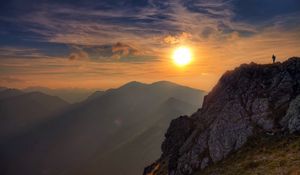 Preview wallpaper sun, light, rock, person, clouds, sky, height, climber, conquest