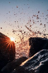 Preview wallpaper sun, rays, stones, spray, water