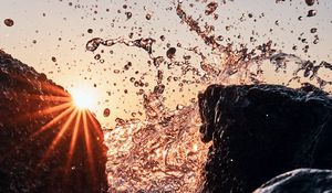 Preview wallpaper sun, rays, stones, spray, water