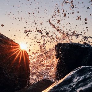 Preview wallpaper sun, rays, stones, spray, water