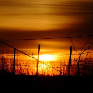 Preview wallpaper sun, sunset, silhouettes, grass, clouds, sky, dark