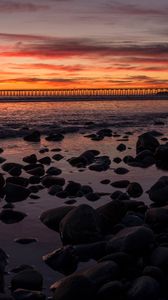 Preview wallpaper sunset, bridge, sea, stones, horizon