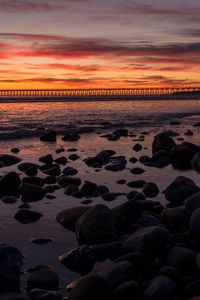 Preview wallpaper sunset, bridge, sea, stones, horizon
