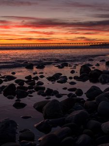 Preview wallpaper sunset, bridge, sea, stones, horizon