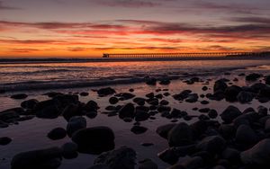 Preview wallpaper sunset, bridge, sea, stones, horizon