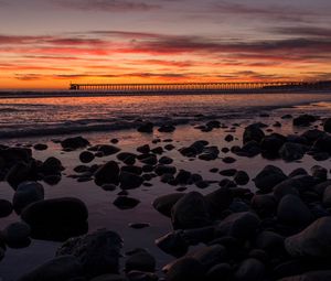 Preview wallpaper sunset, bridge, sea, stones, horizon