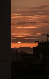 Preview wallpaper sunset, buildings, silhouettes, sun, clouds, dark