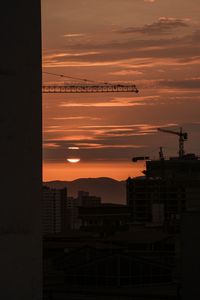 Preview wallpaper sunset, buildings, silhouettes, sun, clouds, dark