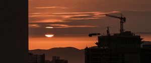 Preview wallpaper sunset, buildings, silhouettes, sun, clouds, dark