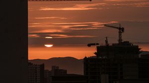 Preview wallpaper sunset, buildings, silhouettes, sun, clouds, dark