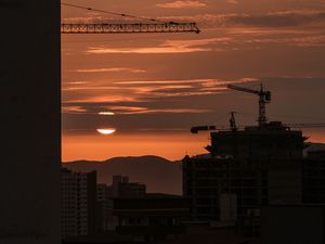 Preview wallpaper sunset, buildings, silhouettes, sun, clouds, dark