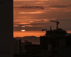 Preview wallpaper sunset, buildings, silhouettes, sun, clouds, dark