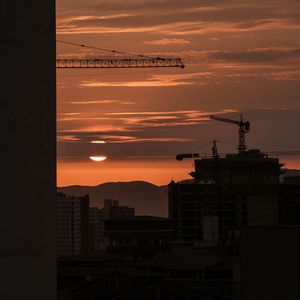 Preview wallpaper sunset, buildings, silhouettes, sun, clouds, dark