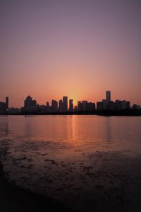 Preview wallpaper sunset, city, building, rays, sea