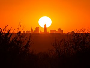 Preview wallpaper sunset, city, buildings, silhouette, sun, dusk