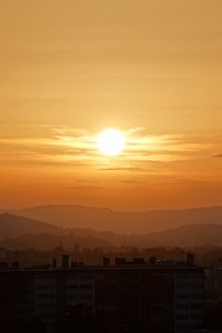Preview wallpaper sunset, city, buildings, mountains, dusk
