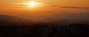 Preview wallpaper sunset, city, buildings, mountains, dusk