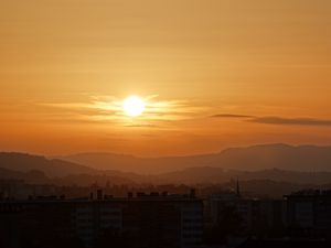 Preview wallpaper sunset, city, buildings, mountains, dusk