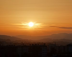 Preview wallpaper sunset, city, buildings, mountains, dusk
