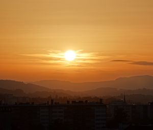 Preview wallpaper sunset, city, buildings, mountains, dusk