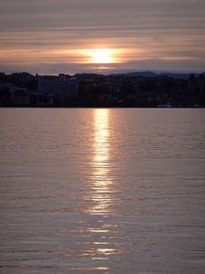 Preview wallpaper sunset, city, coast, buildings, water