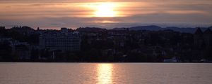 Preview wallpaper sunset, city, coast, buildings, water