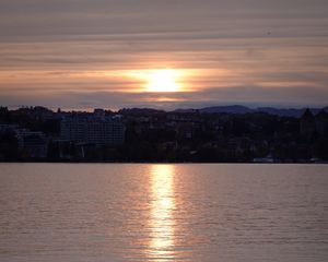 Preview wallpaper sunset, city, coast, buildings, water