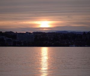 Preview wallpaper sunset, city, coast, buildings, water