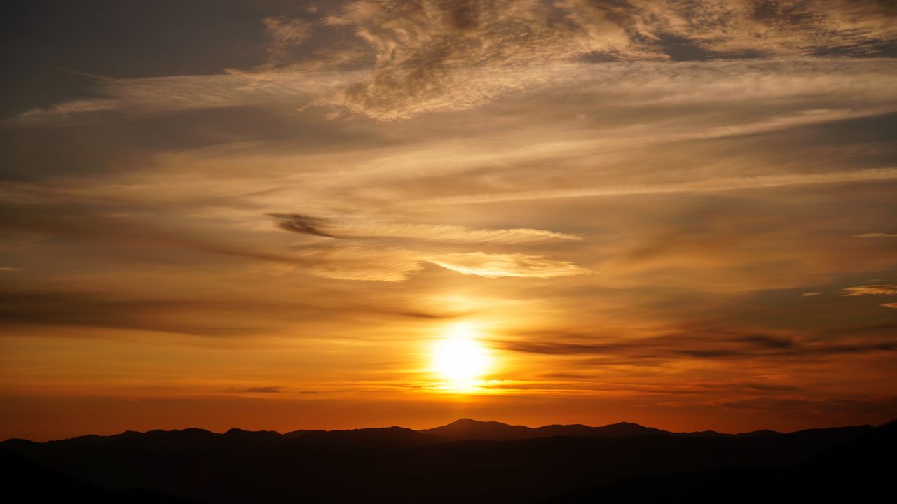 Wallpaper sunset, clouds, hills, sun, sky