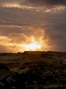 Preview wallpaper sunset, clouds, stones, sand, nature