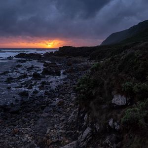 Preview wallpaper sunset, coast, stones, sea, horizon