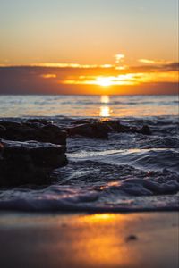 Preview wallpaper sunset, glare, sea, stones, rocks