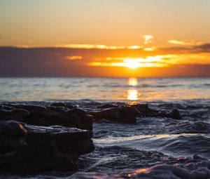 Preview wallpaper sunset, glare, sea, stones, rocks