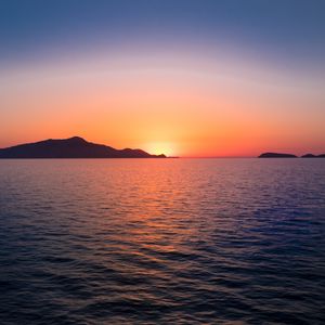 Preview wallpaper sunset, hills, sea, glare, sky
