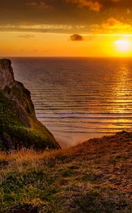 Preview wallpaper sunset, horizon, rock, water surface, grass