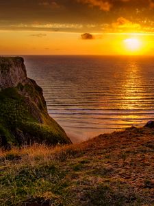 Preview wallpaper sunset, horizon, rock, water surface, grass