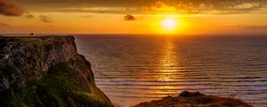 Preview wallpaper sunset, horizon, rock, water surface, grass