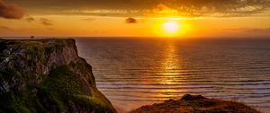 Preview wallpaper sunset, horizon, rock, water surface, grass