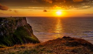 Preview wallpaper sunset, horizon, rock, water surface, grass