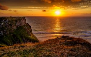 Preview wallpaper sunset, horizon, rock, water surface, grass