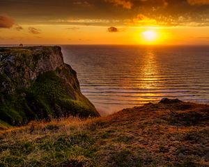 Preview wallpaper sunset, horizon, rock, water surface, grass