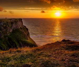 Preview wallpaper sunset, horizon, rock, water surface, grass