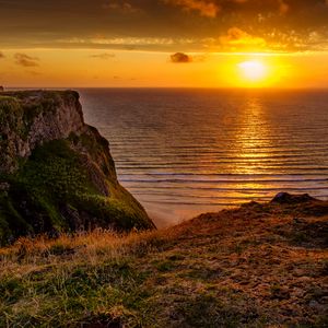 Preview wallpaper sunset, horizon, rock, water surface, grass