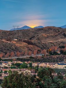 Preview wallpaper sunset, mountains, buildings, trees