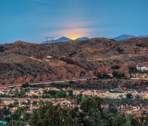 Preview wallpaper sunset, mountains, buildings, trees