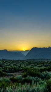 Preview wallpaper sunset, mountains, grass, distance