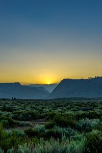 Preview wallpaper sunset, mountains, grass, distance