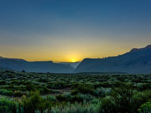 Preview wallpaper sunset, mountains, grass, distance